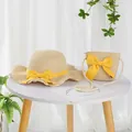Detail of girls' straw sun hat and matching crossbody bag with yellow ribbon bows - S Kids Size / Lotus Leaf Hat and Bag Set / Beige