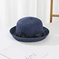 Detailed view of dark blue straw hat weave with elegant black ribbon bow decoration - Navy Blue