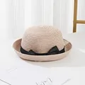 Close-up of fine straw weave texture and elegant black satin ribbon bow on sun hat - Pink