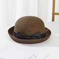 Detail of a dark brown straw sun hat with a black grosgrain ribbon bow decoration - Kids / Coffee