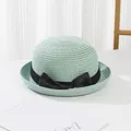 Detail of light green woven straw hat with elegant black grosgrain ribbon bow decoration - Green