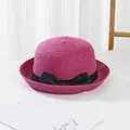 Detail of hot pink straw hat featuring fine spiral weave texture and a black ribbon bow - Rose Red