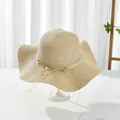 Elegant beige wide-brim straw sun hat with pearl ribbon decoration and wavy edge - M / Beige