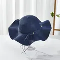 Close-up of wavy brim navy straw hat with decorative pearls and bow detail - M / Navy Blue