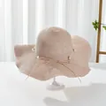 Detail of elegant pink straw sun hat with pearls and a delicate bow for summer vacation - M / Pink