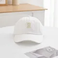Nahaufnahme der beigen R-Buchstaben-Stickerei auf weißer Baumwoll-Baseballkappe - S Kinder (48-52CM) / Weiß