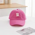 Detailansicht der rosaroten Baumwollkappe mit weißem R-Buchstaben-Stickmuster - Fuchsia
