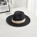 Detail of classic black straw fedora featuring a beige ribbon bow on a white table - M (56-58cm) / Beige Ribbon - Black