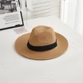 Detail of a brown woven straw fedora hat with a black satin ribbon on a white table - M / Black Ribbon - Khaki