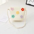 Detailansicht der Stroh-Eimertasche mit bunten Häkelblumen für Mädchen am Strand - Creme