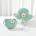 Close-up of kids light green woven straw hat and matching bag with white floral accents - Kids Hat / Mint Green
