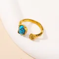 Detalle de anillo ajustable dorado con piedra turquesa y diseño de grano metálico - US 6 / Dorado Turquesa