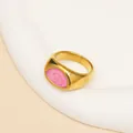 Detail van een vergulde titanium stalen ring met roze marmeren emaille inleg - US 6 / Goud Roze Emaille