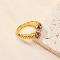 Vue détaillée de la bague dorée nervurée avec pierres de zircon violettes en goutte - US 6 / Or Pierre Violette