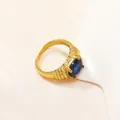 Dettaglio dell'anello con pietra blu ovale e texture dorata a strisce - US 6 / Oro Blu