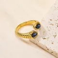 Détail d'une bague dorée vintage avec zircon bleu taille poire et texture spirale - Or Noir Minéral