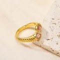 Bague torsadée plaquée or 18 carats avec deux pierres roses taille poire sur support - Or Rose