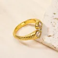Détail d'une bague ouverte dorée avec zircon poire et texture à rayures horizontales - Or Blanc
