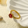 Detailweergave van een 18k vergulde ring met kralenmotief en rode edelsteen zetting - Goud Roosrood Zirkonia