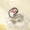 Detailansicht eines verstellbaren Rings mit rosa Zirkonia im Prinzessschliff und Spiraldetail - Einstellbar Offen / Edelstahl Silberfarbe Rosa Zirkonia