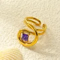 Makroaufnahme eines vergoldeten Rings mit quadratischem lila Zirkon und Wellendesign - Einstellbar Offen / Gold Violetter Zirkonia