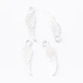 Macro detail of four silver zinc alloy feather wing pendants with intricate engraved textures - Bright Silver