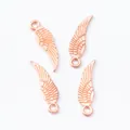 Close-up of four rose gold wing charms for jewelry making with feather texture - Rose Gold