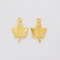 Detailed macro view of two golden maple leaf alloy pendants with intricate vein textures - Gold