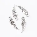 Four vintage silver zinc alloy wing charms for DIY jewelry making on white background - Antique Silver