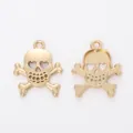 Macro shot of gold skull and crossbones pendants showing front and back alloy details - KC Gold