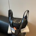 Elegant black crescent shoulder bag with silver rivet details and adjustable leather strap - Black