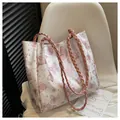 White tote bag with pink butterfly print and pink braided shoulder strap on a chair - 29*12*28 / Pink