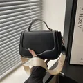 Classic black saddle bag with wide cream fabric strap and elegant gold hardware details - Black