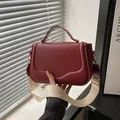 Dark red matte leather crossbody saddle bag with a wide cream-colored fabric strap - Red
