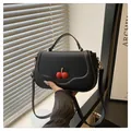Sac bandoulière tendance en cuir noir avec ornement cerise rouge brillant et poignée - Noir