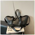 Fashionable black leather tote bag with knotted drawstring detail and long shoulder strap - Black