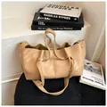 Minimalist khaki leather tote bag with unique pleated texture and knotted handle detail - Khaki