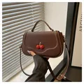 Sac bandoulière en cuir mat marron avec fermoir cerise rouge et poignée supérieure - Café