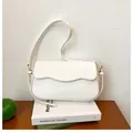 Minimalistische weiße Schultertasche mit gewellter Klappe und goldenen Details - Weiß