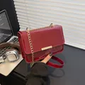 Stylish burgundy patent leather shoulder bag with gold chain strap and sleek buckle - Red