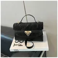 Sac bandoulière trapèze noir chic avec texture plissée et fermoir doré sur livres - Noir