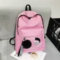 Dettaglio dello zaino in nylon rosa con tasca frontale a zip e ciondolo a sfera di peluche - 15 Pollici / Rosa