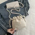 Beige geweven bucket bag met madeliefjesborduurwerk en visgraatmotief textuur - Broken Wit
