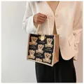 Dettaglio della borsa in lino con stampe di orsetti e chiusura con bottone in legno - Nero