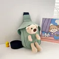 Detalle del bolso de lona verde claro con un oso de peluche 3D y correa negra ajustable - Verde