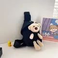 Detalle de riñonera de lona negra con un oso de peluche 3D y correa ajustable resistente - Negro