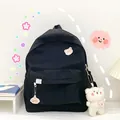 Minimalist black canvas school backpack for girls featuring cute bear plush and pins - Black
