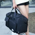 Detalle de una gran bolsa deportiva negra con asas reforzadas y etiqueta de marca - Negro