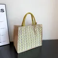Handmade jute tote bag with yellow geometric V-pattern and braided top handles - Yellow