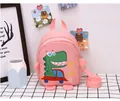 Pink toddler backpack featuring a cartoon dinosaur print and adjustable fabric straps - Pink